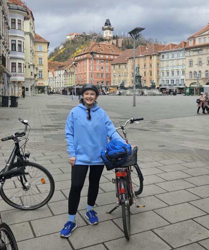 Гідеса в Граці стоїть біля свого велосипеду на головній площі міста